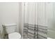 Clean bathroom with a toilet and a bathtub featuring a stylish shower curtain at 1504 Lemon Balm Ct, Lawrenceville, GA 30045