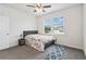 Cozy bedroom with a ceiling fan, gray carpet, and natural light coming in from the window at 1504 Lemon Balm Ct, Lawrenceville, GA 30045