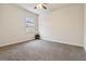 Carpeted bedroom with a ceiling fan and window providing natural light at 1504 Lemon Balm Ct, Lawrenceville, GA 30045