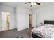 Bedroom with an open bathroom and closet; featuring neutral walls, carpeted floors, and a ceiling fan at 1504 Lemon Balm Ct, Lawrenceville, GA 30045