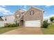Classic brick home with attached garage, complemented by a lush green lawn and mature landscaping at 1504 Lemon Balm Ct, Lawrenceville, GA 30045