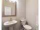 Functional half-bathroom with a pedestal sink and neutral color scheme at 1504 Lemon Balm Ct, Lawrenceville, GA 30045
