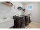 Laundry room includes a utility sink and modern, front-loading washer and dryer at 1504 Lemon Balm Ct, Lawrenceville, GA 30045