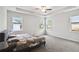 Primary bedroom with a tray ceiling, ceiling fan, carpeted floors, and plenty of natural light from the windows at 1504 Lemon Balm Ct, Lawrenceville, GA 30045