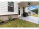 Covered patio featuring direct access to a lush backyard, next to the home's door and windows at 1504 Lemon Balm Ct, Lawrenceville, GA 30045