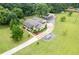 Aerial view of home with lush landscaping, long driveway, and sprawling green lawn at 4067 Mason Creek Rd, Winston, GA 30187