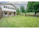 Expansive backyard featuring lush green grass, white siding, and stone pillars supporting the covered patio at 4067 Mason Creek Rd, Winston, GA 30187