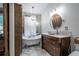 Bathroom featuring a standalone tub with a chandelier, shutters, and a single sink vanity at 4067 Mason Creek Rd, Winston, GA 30187