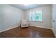 Cozy bedroom featuring a comfortable recliner, plantation shutters, and hardwood floors at 4067 Mason Creek Rd, Winston, GA 30187