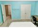 Bright blue bedroom featuring a desk, chair, large neutral carpet, and double doors at 4895 Smokestone Dr, Douglasville, GA 30135