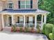 Inviting front porch featuring decorative columns, a cozy seating area, and beautiful blooming flowers at 4895 Smokestone Dr, Douglasville, GA 30135