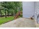 View of the backyard with a concrete patio and wooden stairs leading to a deck at 1634 Crittenden Ln, Lawrenceville, GA 30043
