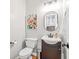 Stylish half-bathroom with modern fixtures, a decorative mirror, and appealing floral artwork at 1634 Crittenden Ln, Lawrenceville, GA 30043
