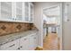 Butler's pantry with granite countertop, white cabinets, and access to gourmet kitchen with stainless appliances at 1634 Crittenden Ln, Lawrenceville, GA 30043