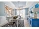 Light-filled dining room features modern chandelier, blue accent wall, and staircase access at 1634 Crittenden Ln, Lawrenceville, GA 30043