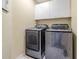 Laundry room featuring a modern washer and dryer set, with overhead cabinets at 1634 Crittenden Ln, Lawrenceville, GA 30043