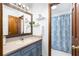 Bright bathroom with a blue vanity, shower with a blue shower curtain, and white walls at 2747 Livsey Trl, Tucker, GA 30084
