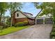 View of home's exterior with attached two-car garage, brick accents, and manicured lawn at 2747 Livsey Trl, Tucker, GA 30084