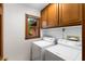 Functional laundry room with washer, dryer, and overhead cabinets for storage at 2747 Livsey Trl, Tucker, GA 30084