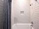 Bright bathroom showcasing a white tiled shower with a built-in niche and a shower curtain at 625 Piedmont Ne Ave # 2004, Atlanta, GA 30308