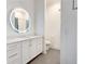 Bathroom vanity with illuminated round mirror and view into a separate room with toilet and shower at 625 Piedmont Ne Ave # 2004, Atlanta, GA 30308