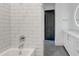 Modern bathroom with a white tiled shower, vanity with white cabinets, and gray tile floors at 625 Piedmont Ne Ave # 2004, Atlanta, GA 30308