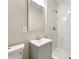 Modern bathroom featuring a white marbled shower, gray vanity, and bright mirror at 1396 Elizabeth Ln, Atlanta, GA 30344