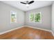 Bright bedroom featuring hardwood floors, ceiling fan, and two windows overlooking the yard at 1396 Elizabeth Ln, Atlanta, GA 30344
