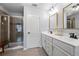 Beautiful bathroom features a glass-enclosed shower, double sinks, gold framed mirrors and wood-look tile at 2069 Brightleaf Way # 123, Marietta, GA 30060
