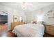 Bright bedroom with hardwood floors, crystal chandelier, vintage dresser and a rainbow accent pillow at 2069 Brightleaf Way # 123, Marietta, GA 30060