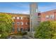 Brick building with many windows and a modern tower set amongst mature landscaping with parking in view at 490 Marietta St Nw # 307, Atlanta, GA 30313