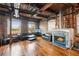 Living room with fireplace, hardwood floors, exposed brick, and large windows with city views at 490 Marietta St Nw # 307, Atlanta, GA 30313