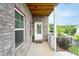 Cozy covered porch featuring brick accents, a white door, and manicured landscaping at 831 Corsiglia Farm Flts, Marietta, GA 30060