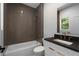 Modern bathroom featuring horizontal tiled shower, dark countertops, and gold faucet fixtures at 1186B Francis Nw St, Atlanta, GA 30318