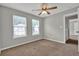 Bedroom featuring neutral carpet, ceiling fan and light, and two windows at 3822 River Ridge Ct, Decatur, GA 30034