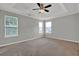 A bedroom with tray ceilings, three windows, and a ceiling fan at 3822 River Ridge Ct, Decatur, GA 30034