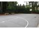 Community basketball court with new paint and a bench, surrounded by lush greenery for privacy at 4179 Westchester Ne Xing, Roswell, GA 30075