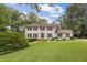 Traditional two-story home with a lush front lawn and mature trees providing shade and curb appeal at 4179 Westchester Ne Xing, Roswell, GA 30075