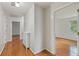 Hallway with hardwood flooring leads to an open doorway, and features a white cabinet at 4179 Westchester Ne Xing, Roswell, GA 30075