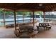 Covered picnic pavilion with multiple picnic tables and benches with a view of the tennis courts at 4179 Westchester Ne Xing, Roswell, GA 30075