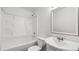 Clean, white bathroom with tub and shower combination and a bright vanity mirror at 49 Country Ct, Alpharetta, GA 30005