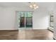 Open dining area with hardwood floors, modern chandelier, and view of a fenced backyard at 49 Country Ct, Alpharetta, GA 30005