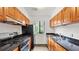 Galley kitchen with black appliances, granite countertops, and hardwood cabinets at 49 Country Ct, Alpharetta, GA 30005
