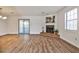 Spacious living area featuring a cozy fireplace, laminate floors, and sliding doors to the outside patio at 6035 Wintergreen Rd, Norcross, GA 30093