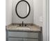 Stylish half-bath with a modern round mirror, granite counters, and vanity at 95 Old Town Rd, Dacula, GA 30019