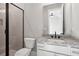 Well-lit bathroom with a glass enclosed shower, toilet, granite counters and vanity at 95 Old Town Rd, Dacula, GA 30019