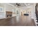 Spacious living room with hardwood floors, brick fireplace, and view into the kitchen at 95 Old Town Rd, Dacula, GA 30019
