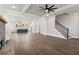 Open-concept living room with hardwood floors, fireplace, staircase, and view of modern kitchen at 95 Old Town Rd, Dacula, GA 30019