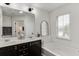 Bathroom featuring a large tub, dark cabinets, double sinks, and a window view at , Lawrenceville, GA 30044
