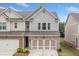 Charming townhouse with brick and siding exterior, featuring a two-car garage and well-maintained landscaping at 109 Camden Park Dr, Woodstock, GA 30188